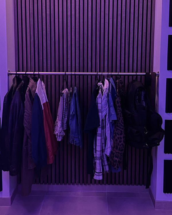 Clothes rail in the studio, in front of a slatted acoustic wall